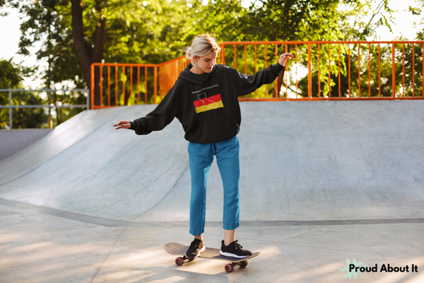 woman skate boarding wearing an oversized black German Californian Unisex Hoodie | German Heritage, California Style